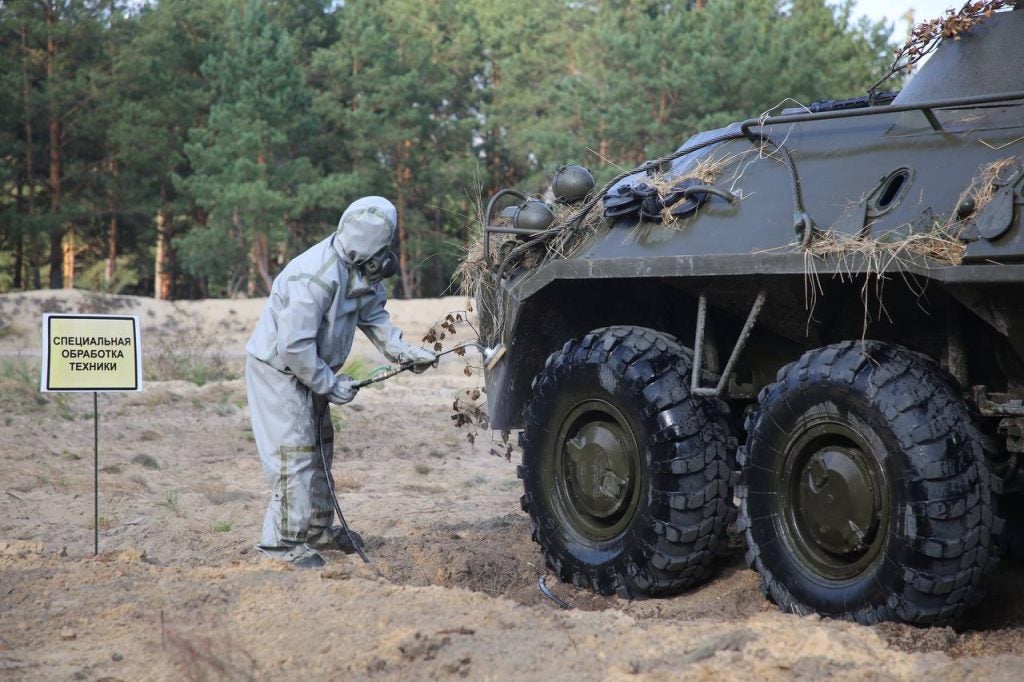 A soldier at the Bretsky training grounds in protective clothing disinfects a BTR-82A armored personnel carrier, September 2, 2023. Image by the Ministry of Defense of Belarus.
